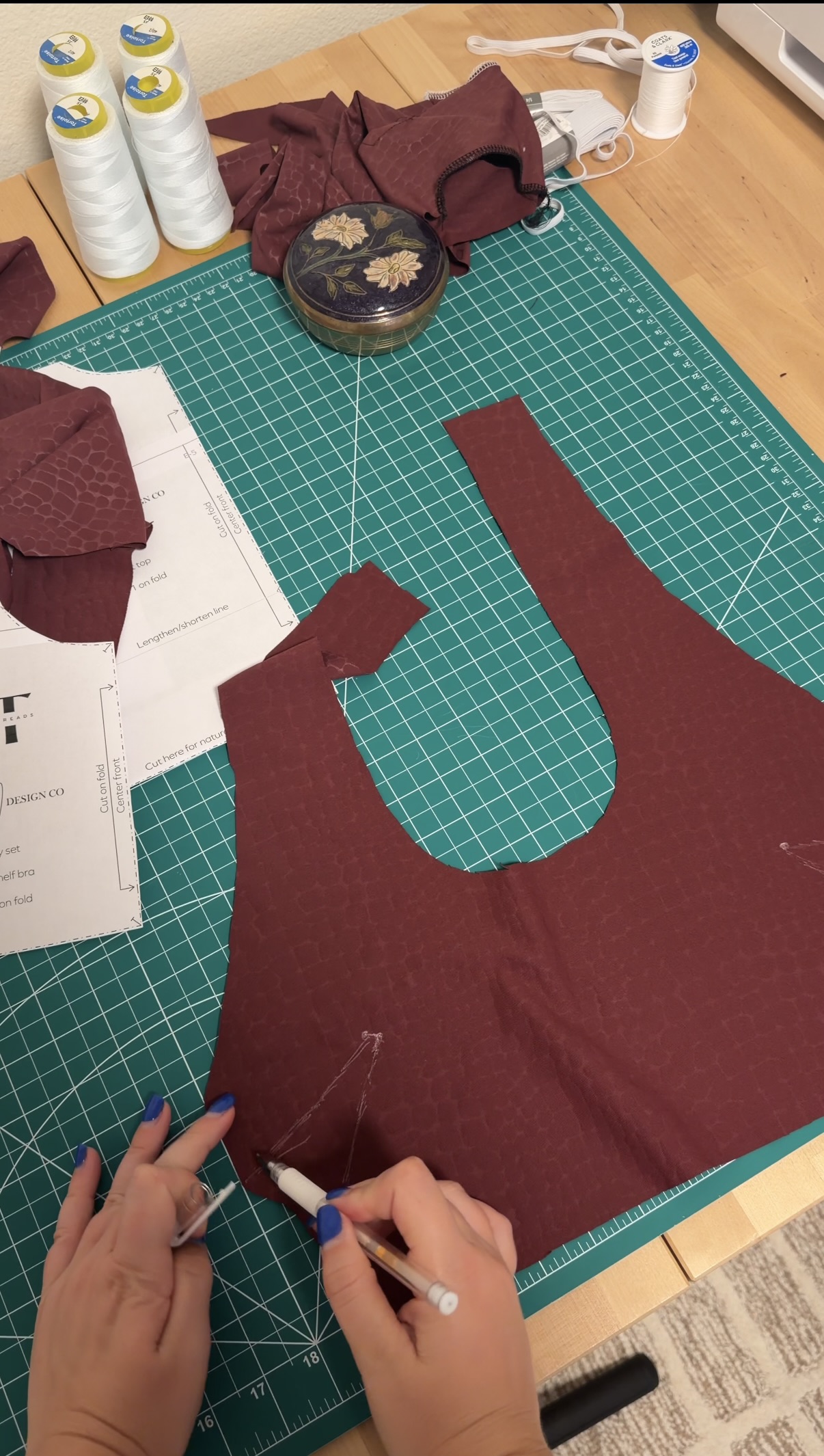 The cut top piece from the Becky set pattern, marking the dart lines on the snake print fabric before sewing